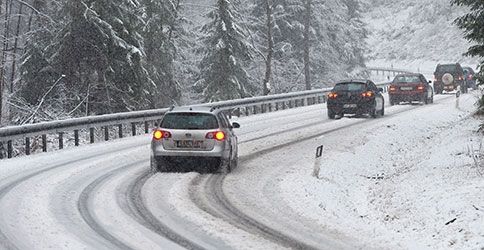 Autos auf einer schneebedeckten Straße Autos auf einer schneebedeckten Straße