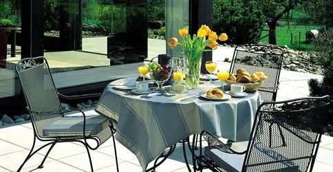 Ein gedeckter Kaffeetisch steht auf einer gefliesten Terrasse Ein gedeckter Kaffeetisch steht auf einer gefliesten Terrasse